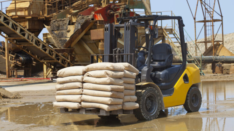 Image of a forklift carrying bags of cement at a construction site